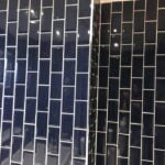 Black natural stone tiling wall with a contrasting grout color, showcasing a sharp corner edge.