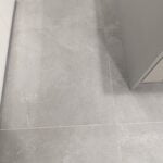 A clean and modern bathroom with gray ceramic tiling.