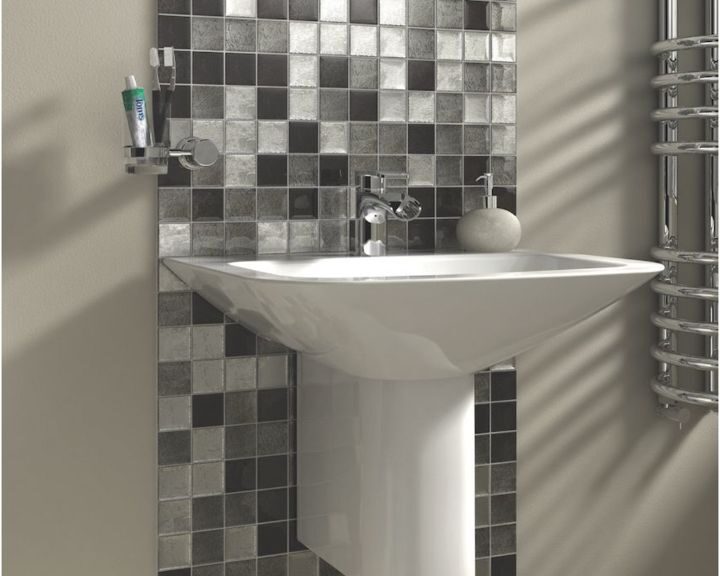 Modern bathroom corner featuring a pedestal sink with a natural stone tiling backsplash and a heated towel rail.