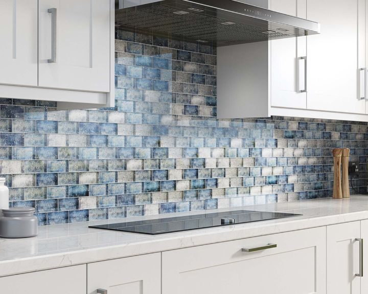 Modern kitchen with blue ceramic tiling backsplash and sleek induction cooktop.