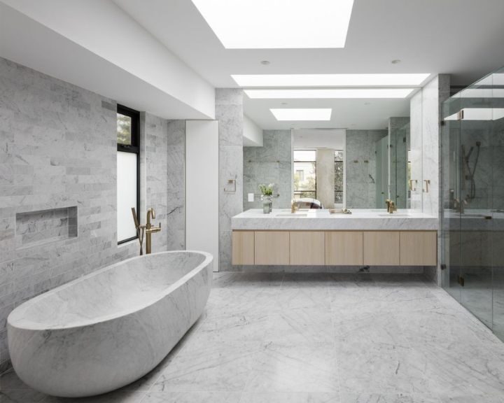 Modern bathroom with porcelain tiling, freestanding tub, and glass shower enclosure.